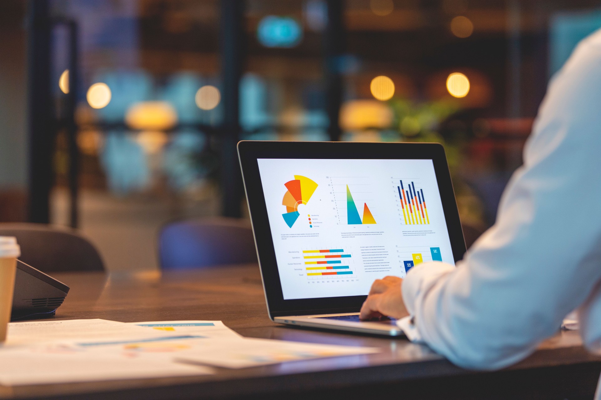 Close up of businessman using a laptop with graphs and charts on a laptop computer.